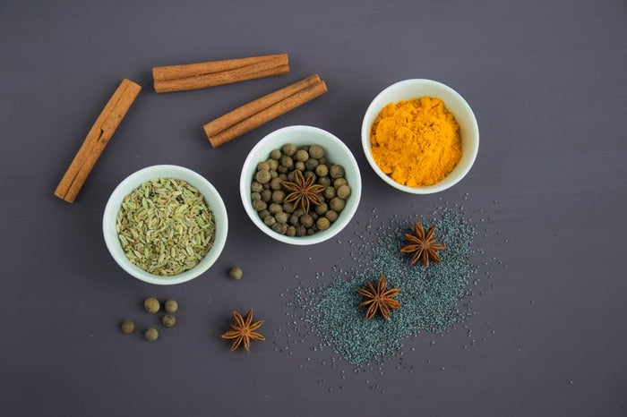 Assorted spice powders in small bowls, flat lay
